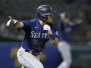 Seattle Mariners' Jake Bauers reacts after hitting a two-run single against the Oakland Athletics during the ninth inning of a baseball game in Oakland, Calif., Monday, Aug. 23, 2021.