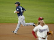 Seattle Mariners' Kyle Seager, rear, rounds the bases after hitting a two-run home run on a pitch from Texas Rangers starting pitcher Mike Foltynewicz, front, in the first inning of a baseball game in Arlington, Texas, Wednesday, Aug. 18, 2021.