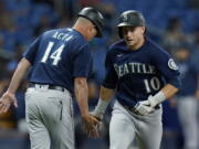 Seattle Mariners' Jarred Kelenic (10) celebrates with third base coach Manny Acta (14) after his solo home run off Tampa Bay Rays pitcher Luis Patino during the fourth inning of a baseball game Tuesday, Aug. 3, 2021, in St. Petersburg, Fla.