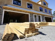 Lumber is piled June 24 at a housing construction site in Middleton, Mass. Wood prices have skyrocketed over the last year, leaving would-be home renovators deciding whether to wait out the high costs or move forward on a project that's more expensive than it would have been a year ago.