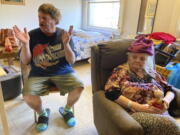 Karen Colby listens on July 22, 2021 in Portland, Ore., while her neighbor Joel Aslin tells how he called an ambulance for her when she got heat stroke as temperatures reached 107 F in her small fifth-floor studio apartment during a record-breaking heat wave in June. The unprecedented heat, which reached 116 F in Portland, killed dozens of people in Oregon and hundreds across the region and was a wake-up call for the normally cool region as climate change accelerates.