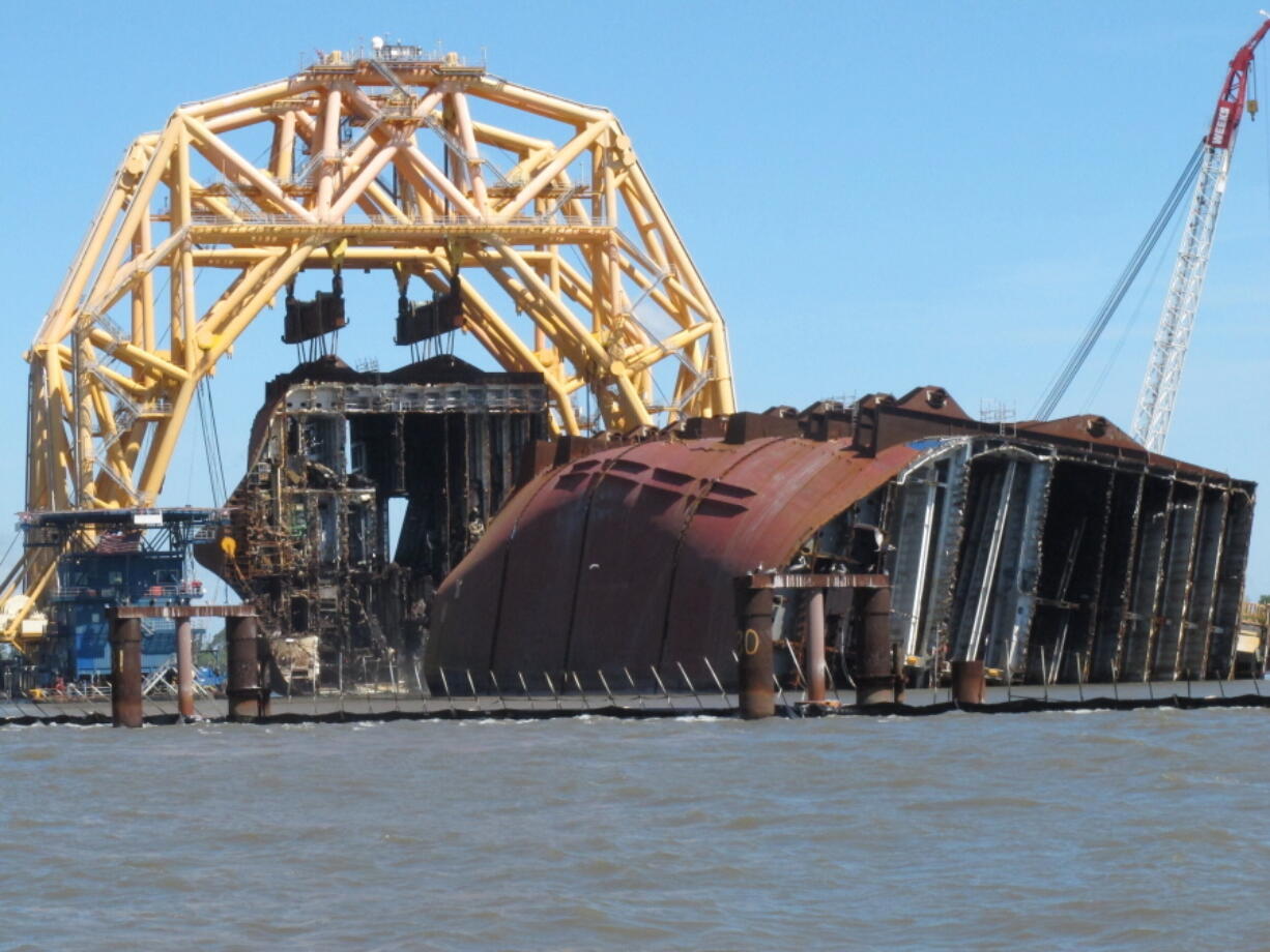 FILE - In this April 26, 2021 file photo, a towering crane pulls the engine room section away from the remains of the capsized cargo ship Golden Ray offshore of St. Simons Island, Ga.  Accounts contained in crew member interviews are among more than 1,700 pages of documents made public Thursday, July 29, by the National Transportation Safety Board. The Golden Ray, carrying more than 1,400 vehicles, overturned after leaving the Port of Brunswick along the Georgia coast on Sept. 8, 2019. Tennant and about two dozen crew members on board were rescued and survived.