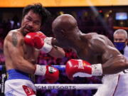 Manny Pacquiao, left, of the Philippines, is hit Yordenis Ugas, of Cuba, in a welterweight championship boxing match Saturday, Aug. 21, 2021, in Las Vegas.