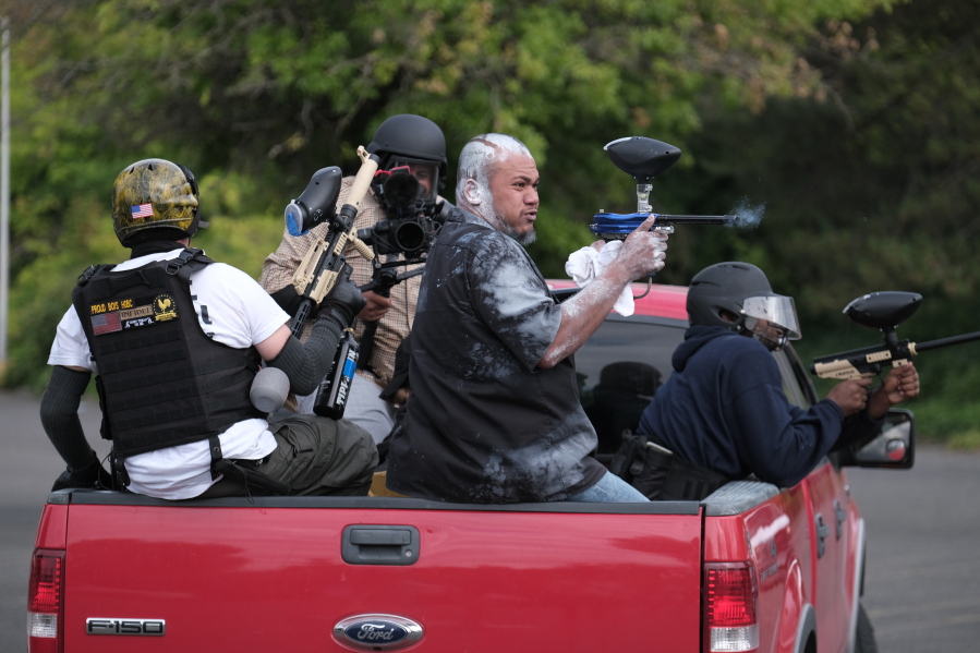 Tusitala "Tiny" Toese, a member of the far-right group Proud Boys, fires paintball rounds at anti-fascist protesters as they depart from their rally on Sunday, Aug. 22, 2021, in Portland, Ore.