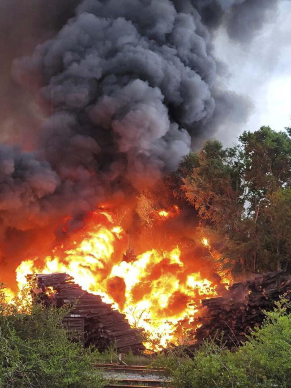 Smoke and fire fill the air from a blaze at  National Salvage and Services Corp., on Monday, Aug. 2, 2021 near Selma, Ala.   The fire that apparently started with a lightning strike and grew so large it showed up on weather radar engulfed a pile of thousands of railroad ties at a recycling plant in rural west Alabama.