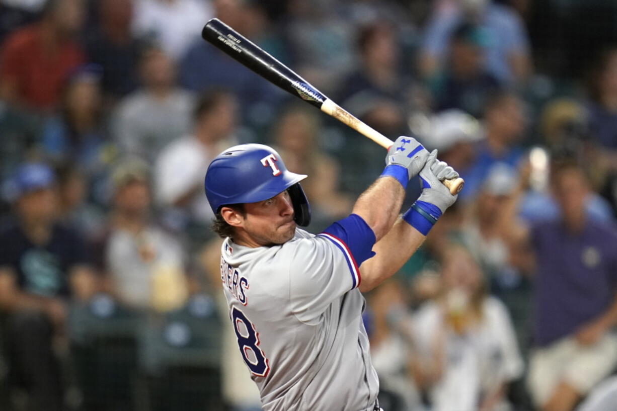 Texas Rangers' DJ Peters drives watches his RBI double against the Seattle Mariners during the fifth inning of a baseball game Tuesday, Aug. 10, 2021, in Seattle.