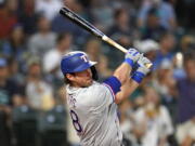 Texas Rangers' DJ Peters drives watches his RBI double against the Seattle Mariners during the fifth inning of a baseball game Tuesday, Aug. 10, 2021, in Seattle.