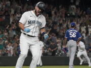 Seattle Mariners' Luis Torrens, left, celebrates his single that scored Jarred Kelenic with the winning run off of Texas Rangers pitcher Dennis Santana (56) during the ninth inning of a baseball game Wednesday, Aug. 11, 2021, in Seattle. The Mariners won 2-1. (AP Photo/Ted S.