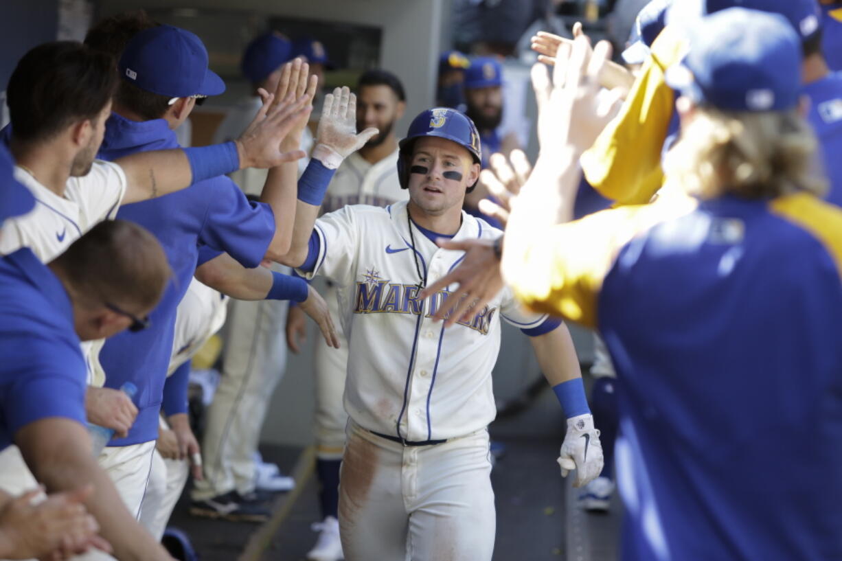 Seattle Mariners' Jarred Kelenic celebrates in the dugout after hitting a solo home run during the sixth inning of a baseball game against the Kansas City Royals, Sunday, Aug. 29, 2021, in Seattle.