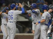 Kansas City Royals' Salvador Perez (13) is greeted at the plate by Emmanuel Rivera (26) after Perez hit a grand slam against the Seattle Mariners during the sixth inning of a baseball game Thursday, Aug. 26, 2021, in Seattle. (AP Photo/Ted S.