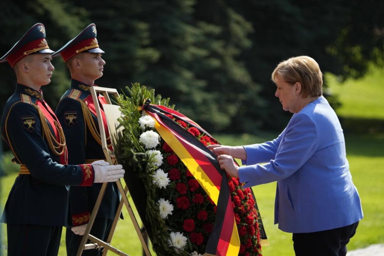 German Chancellor Angela Merkel, right, attends a wreath laying ceremony at the Tomb of Unknown Soldier in Moscow, Russia, Friday, Aug. 20, 2021, prior to talks with Russian President Vladimir Putin. The talks between Merkel and Putin are expected to focus on Afghanistan, the Ukrainian crisis and the situation in Belarus among other issues.