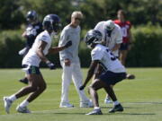 Seattle Seahawks head coach Pete Carroll, center, watches as cornerback Ahkello Witherspoon, left, runs a drill with cornerback Bryan Mills, right, during NFL football practice Thursday, July 29, 2021, in Renton, Wash. (AP Photo/Ted S.