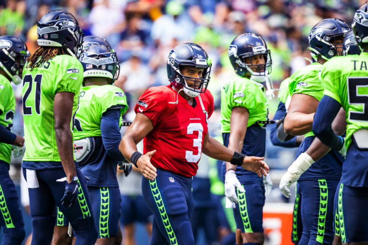 Seattle Seahawks quarterback Russell Wilson (3) greets the defense before playing a mock game as part of an NFL football training camp at Lumen Field in Seattle, Sunday, Aug. 8, 2021.