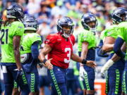 Seattle Seahawks quarterback Russell Wilson (3) greets the defense before playing a mock game as part of an NFL football training camp at Lumen Field in Seattle, Sunday, Aug. 8, 2021.