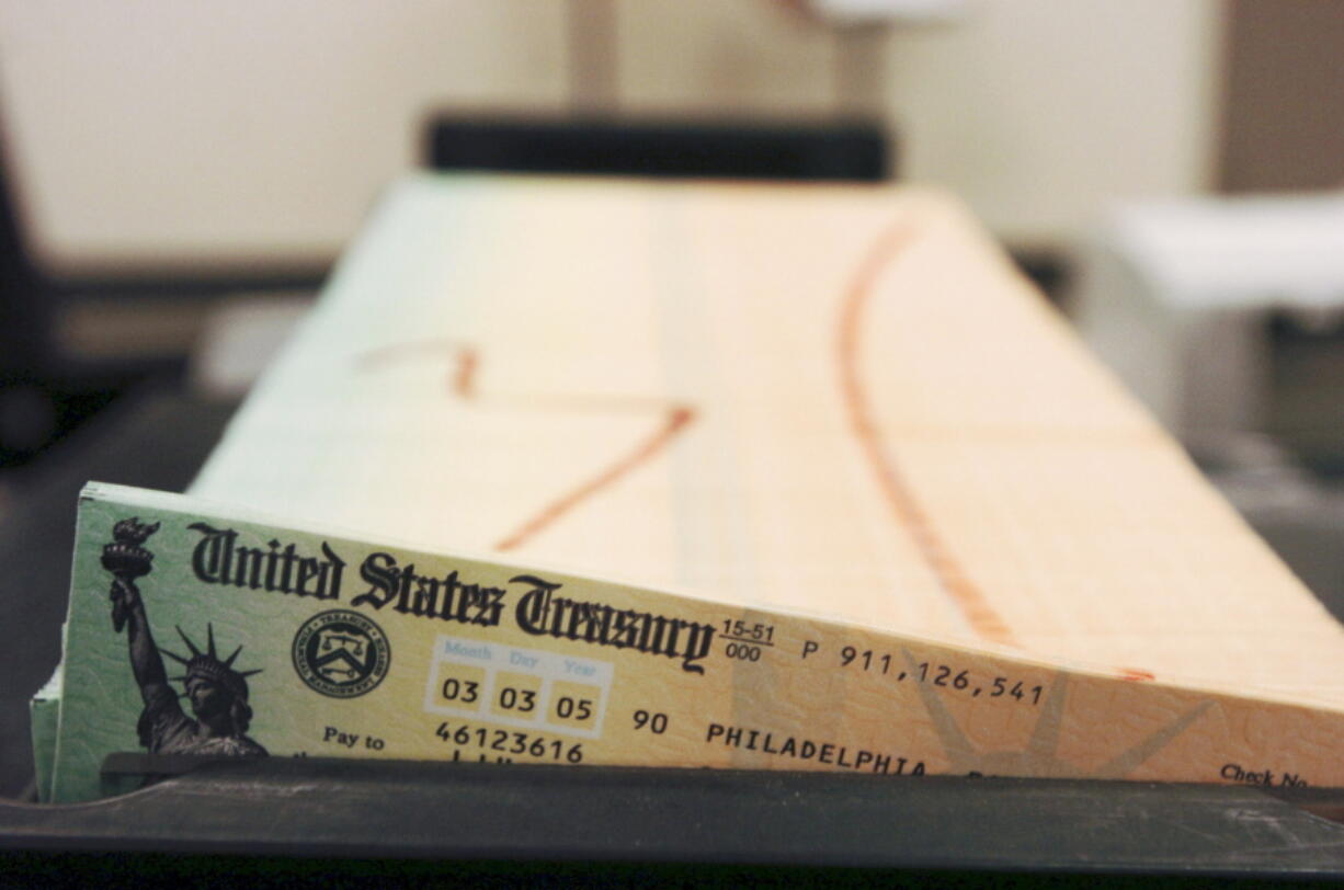 FILE - In this Feb. 11, 2005 file photo, trays of printed social security checks wait to be mailed from the U.S. Treasury's Financial Management services facility in Philadelphia. The financial impact of the coronavirus pandemic on Social Security and Medicare is front and center as the government releases its annual report on the state of the bedrock retirement programs on Tuesday, Aug. 31, 2021. (AP Photo/Bradley C.