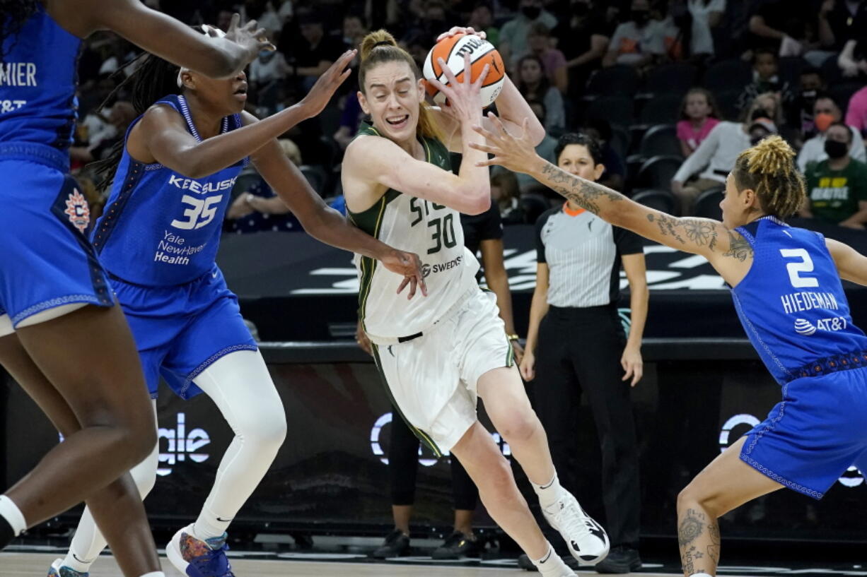 Seattle Storm forward Breanna Stewart (30) drives as Connecticut Sun guard Natisha Hiedeman (2) and forward Jonquel Jones (35) defend during the first half of the Commissioner's Cup WNBA basketball game, Thursday, Aug. 12, 2021, in Phoenix.