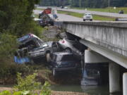 Cars are stacked on top of each other on the banks of Blue Creek being swept up in flood water, Monday, Aug. 23, 2021, in Waverly, Tenn. Heavy rains caused flooding in Middle Tennessee days ago and have resulted in multiple deaths as homes and rural roads were washed away.