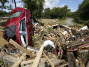 A car is among debris that washed up against a bridge over a stream Sunday, Aug. 22, 2021, in Waverly, Tenn. Heavy rains caused flooding Saturday in Middle Tennessee and have resulted in multiple deaths as homes and rural roads were washed away.