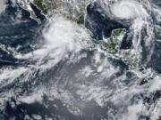 This image provided by the National Oceanic and Atmospheric Administration (NOAA) shows severe weather systems, Hurricane Nora, upper left, and Hurricane Ida, upper right, over the North American continent on Saturday, Aug. 28, 2021. Hurricane Nora is churning northward up Mexico's Pacific Coast toward the narrow Gulf of California, after making a sweep past the Puerto Vallarta area.