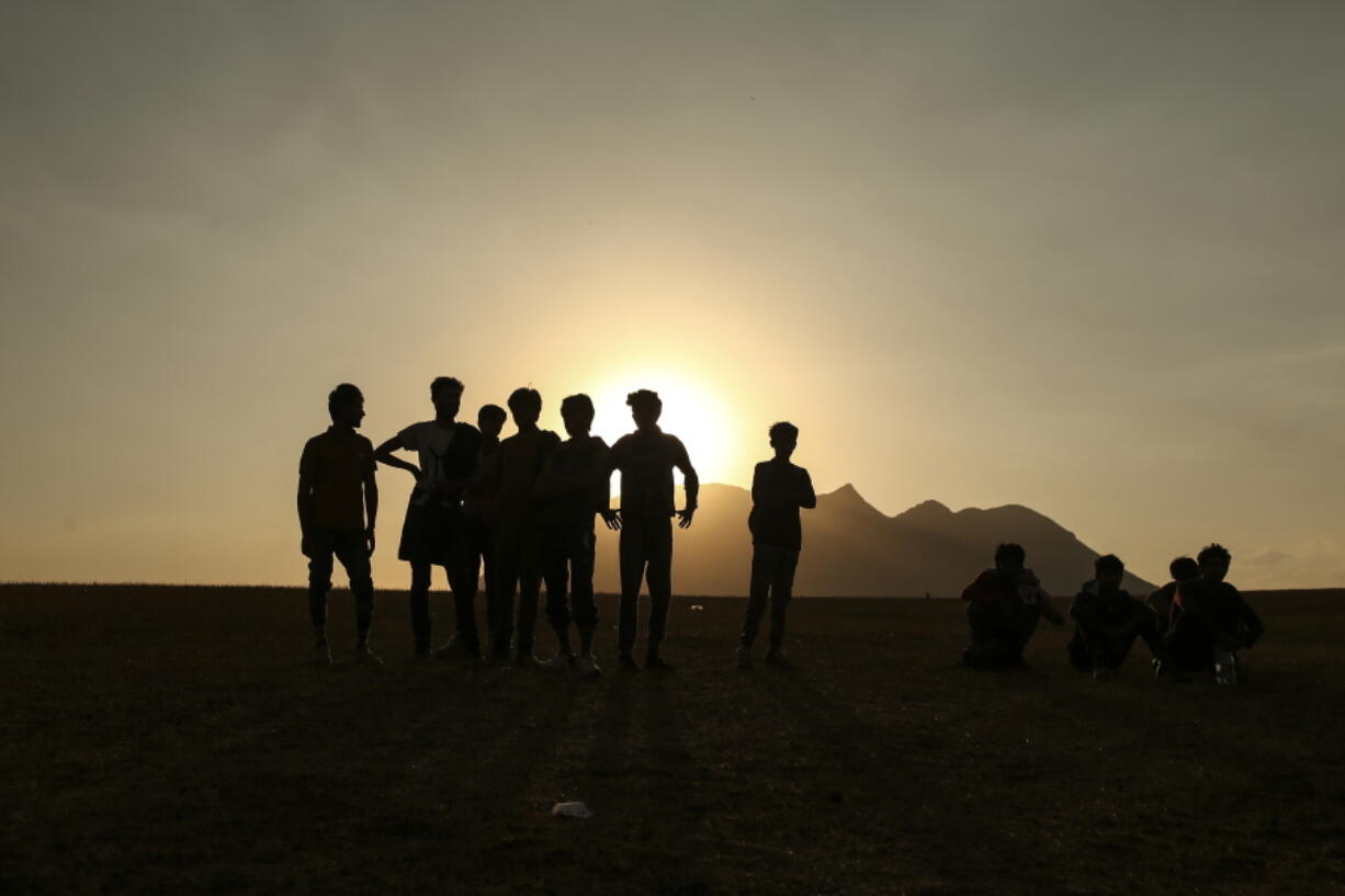 Young men who say they deserted the Afghan military and fled to Turkey through Iran stand in the countryside in Tatvan, in Bitlis Province in eastern Turkey, Tuesday, Aug. 17, 2021.