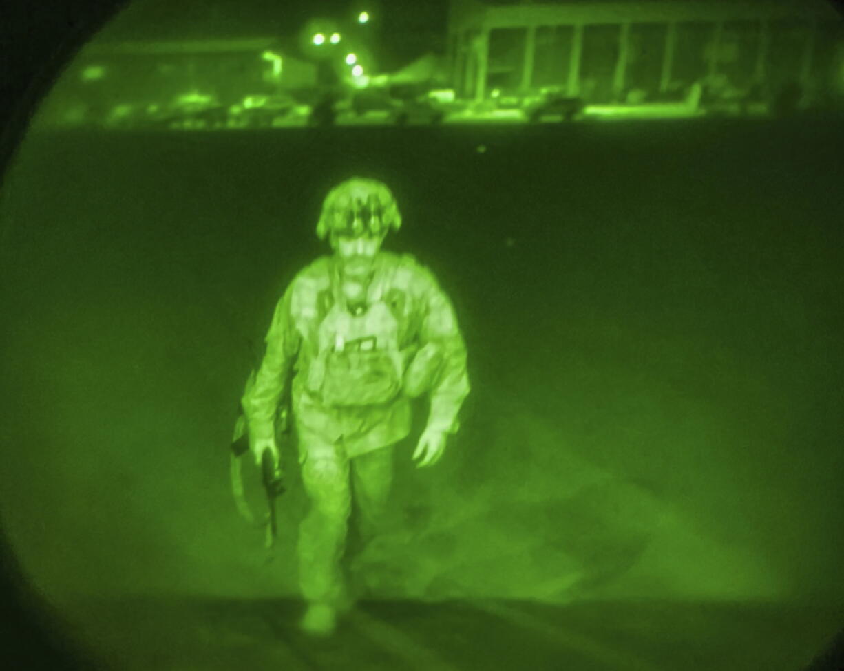 In this image made through a night vision scope and provided by the U.S. Army, Maj. Gen. Chris Donahue, commander of the U.S. Army 82nd Airborne Division, XVIII Airborne Corps, boards a C-17 cargo plane at Hamid Karzai International Airport in Kabul, Afghanistan, Monday, Aug. 30, 2021, as the final American service member to depart Afghanistan. (Master Sgt. Alexander Burnett/U.S.