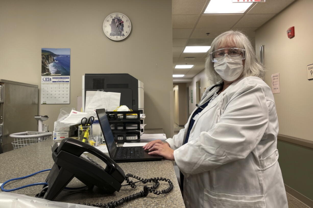 Dr. Sara Goza looks over while working at First Georgia Physician Group Pediatrics in Fayetteville, Ga., Tuesday, Aug. 17, 2021. The vaccinations that U.S. schoolchildren are required to get to hold terrible diseases like polio, hepatitis, tetanus and whooping cough in check are way behind schedule this year, threatening further complications to a school year already marred by COVID-19.