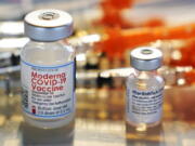 FILE - In this Feb. 25, 2021, file photo, vials for the Moderna and Pfizer COVID-19 vaccines are displayed on a tray at a clinic set up by the New Hampshire National Guard in the parking lot of Exeter, N.H., High School. An untold number of Americans have managed to get COVID-19 booster shots even though the U.S. government hasn't approved them. They're doing so by taking advantage of the nation's vaccine surplus and loose tracking of those who have been fully vaccinated.