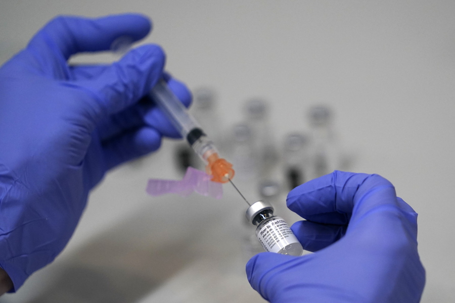 FILE - A pharmacy technician loads a syringe with Pfizer's COVID-19 vaccine, Tuesday, March 2, 2021, at a mass vaccination site at the Portland Expo in Portland, Maine. U.S. experts are expected to recommend COVID-19 vaccine boosters for all Americans, regardless of age, eight months after they received their second dose of the shot, to ensure lasting protection against the coronavirus as the delta variant spreads across the country. An announcement was expected as soon as this week, with doses beginning to be administered widely once the Food and Drug Administration formally approves the vaccines.  (AP Photo/Robert F.