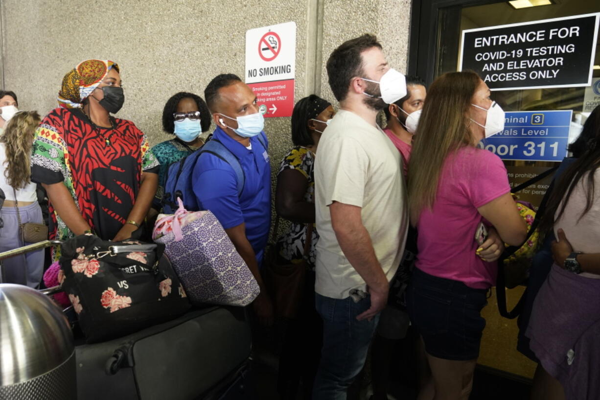 Passengers wait in a long line to get a COVID-19 test to travel overseas at Fort Lauderdale-Hollywood International Airport, Friday, Aug. 6, 2021, in Fort Lauderdale, Fla. Recent flight cancelations caused many passengers to redo their tests while others were unable to get the test locally due to long lines caused by the surge of the Delta variant.