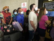 Passengers wait in a long line to get a COVID-19 test to travel overseas at Fort Lauderdale-Hollywood International Airport, Friday, Aug. 6, 2021, in Fort Lauderdale, Fla. Recent flight cancelations caused many passengers to redo their tests while others were unable to get the test locally due to long lines caused by the surge of the Delta variant.