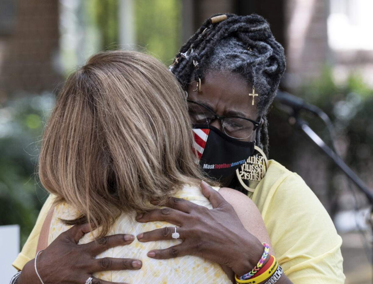 Marjorie Roberts, right, hugs Tanya Washington after speaking about how COVID effected her during a gathering at St. Luke's Episcopal Church in Atlanta on Saturday, Aug. 7, 2021, as part of National COVID Awareness Day.