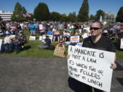 Olympia resident and state employee William Baker along with concerned citizens gather outside the Capitol to protest Gov. Jay Inslee's vaccine mandate for state workers, Saturday, Aug. 28, 2021 in Olympia, Wash.