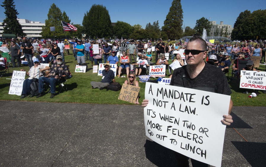 Olympia resident and state employee William Baker along with concerned citizens gather outside the Capitol to protest Gov. Jay Inslee's vaccine mandate for state workers, Saturday, Aug. 28, 2021 in Olympia, Wash.