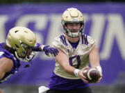 Washington Huskies quarterback Dylan Morris hands-off the ball during an NCAA college football team practice Friday, Aug. 6, 2021, in Seattle.