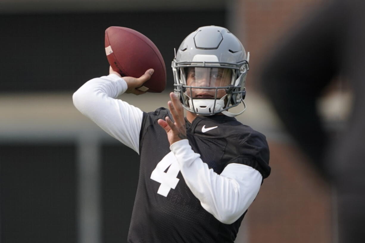 Washington State quarterback Jayden de Laura throws a pass on the first day fall practice in Pullman. (Ted S.