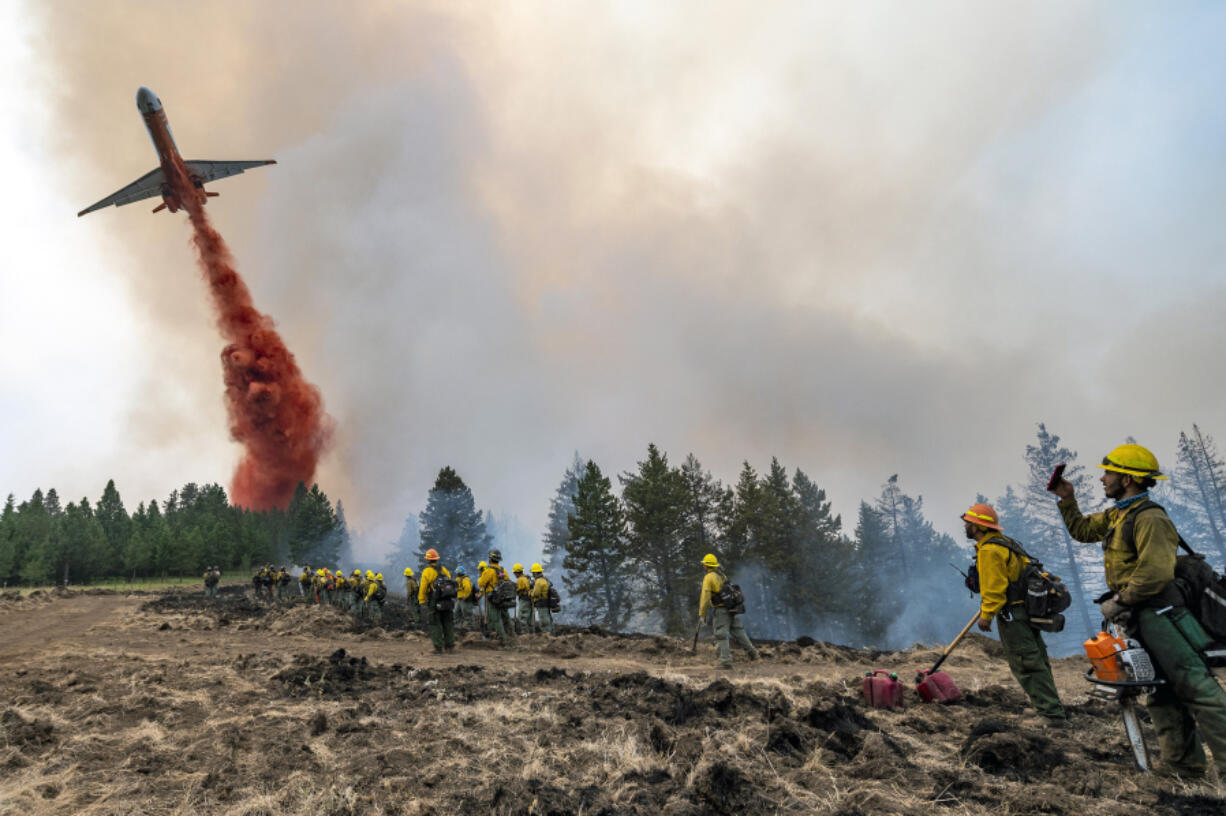 Wildland firefighters watch and take video as a plane drops fire retardant July 12 on Harlow Ridge above the Lick Creek Fire burning in Asotin and Garfield counties. The fire, which burned more than 80,000 acres, is now 100 percent contained.