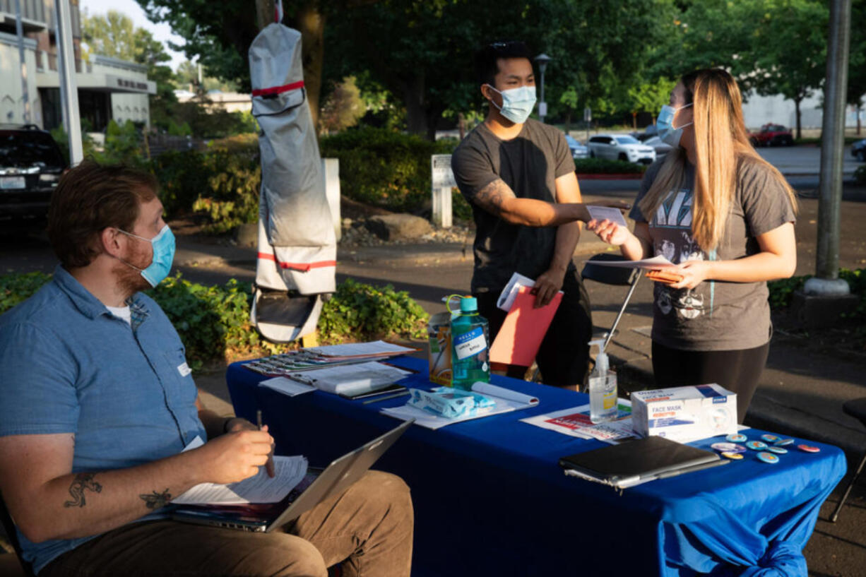 Michael Chu and Sandy Nguyen of Renton visit a King County Public Health pop-up vaccination site together for a vaccine at Renton Library on Aug. 25, 2021. (Matt M.