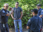 After watching a mock fight during an academy class at the Washington Criminal Justice Training Center in Burien, Washington on Wednesday, August 18, 2021, Steve Woodward, left, a TAC officer with the Washington State Criminal Justice Training Commission, gives advice and instructions regarding improvements that can be made regarding how the recruits handled the situation.  At center is recruit Chad Sommerfield, with the Everett Police Department, second from right is recruit Ryan Rich and at far right is recruit Seth Anderson, both with the Vancouver Police Department. (Ellen M.