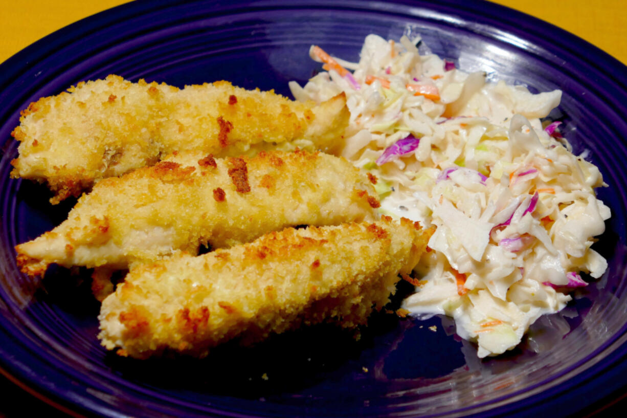 Oven-fried chicken tenders with coleslaw.