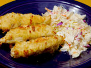 Oven-fried chicken tenders with coleslaw.