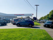 The line at Kaady Car Wash backed up on Mill Plain Boulevard on Wednesday morning after people awoke to their cars covered in ash from early-morning rainfall.