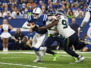 Indianapolis Colts quarterback Carson Wentz (2) scrambles from pressure by Seattle Seahawks defensive end Rasheem Green (94) during the season opener on Sunday, Sept. 12, 2021, in Indianapolis. Green had perhaps his best day as a pro with four tackles, a sack and two pass breakups.