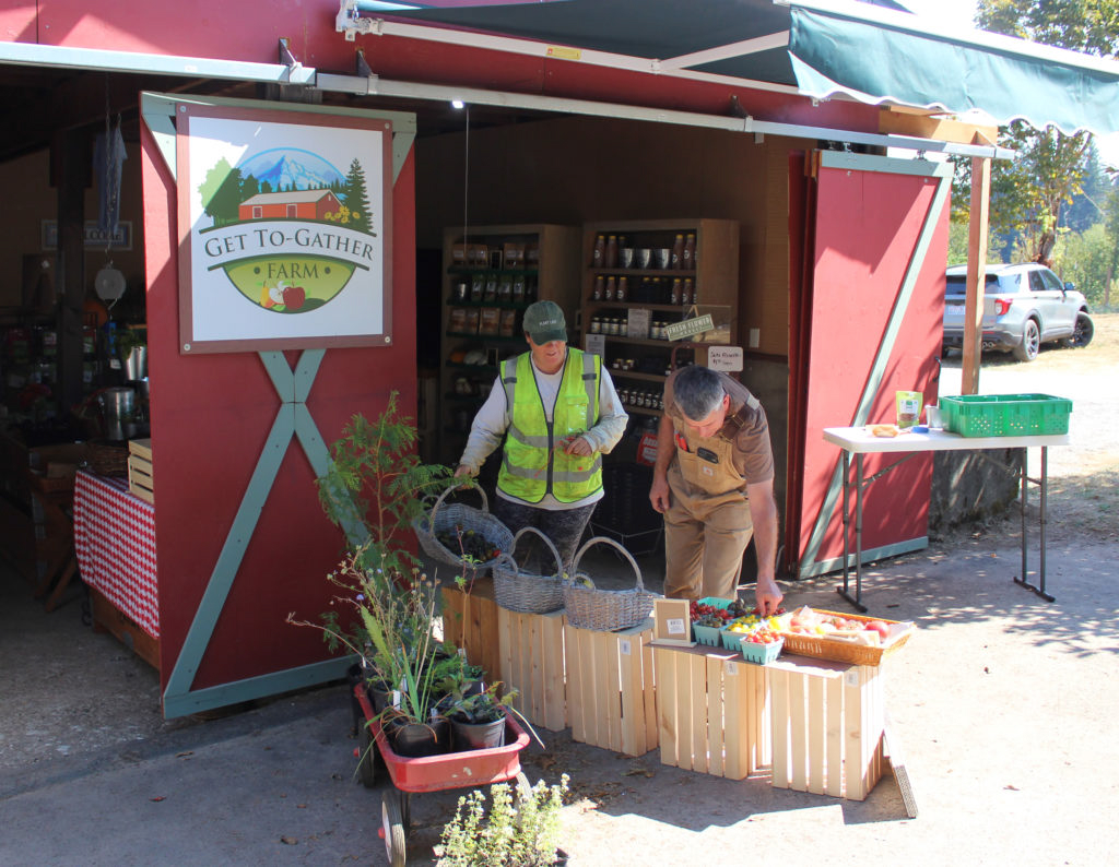 Andra Spencer, left, and John Spencer, show a recent harvest of fruit from their Washougal Get To-Gather retail farm stand on Sept. 2.