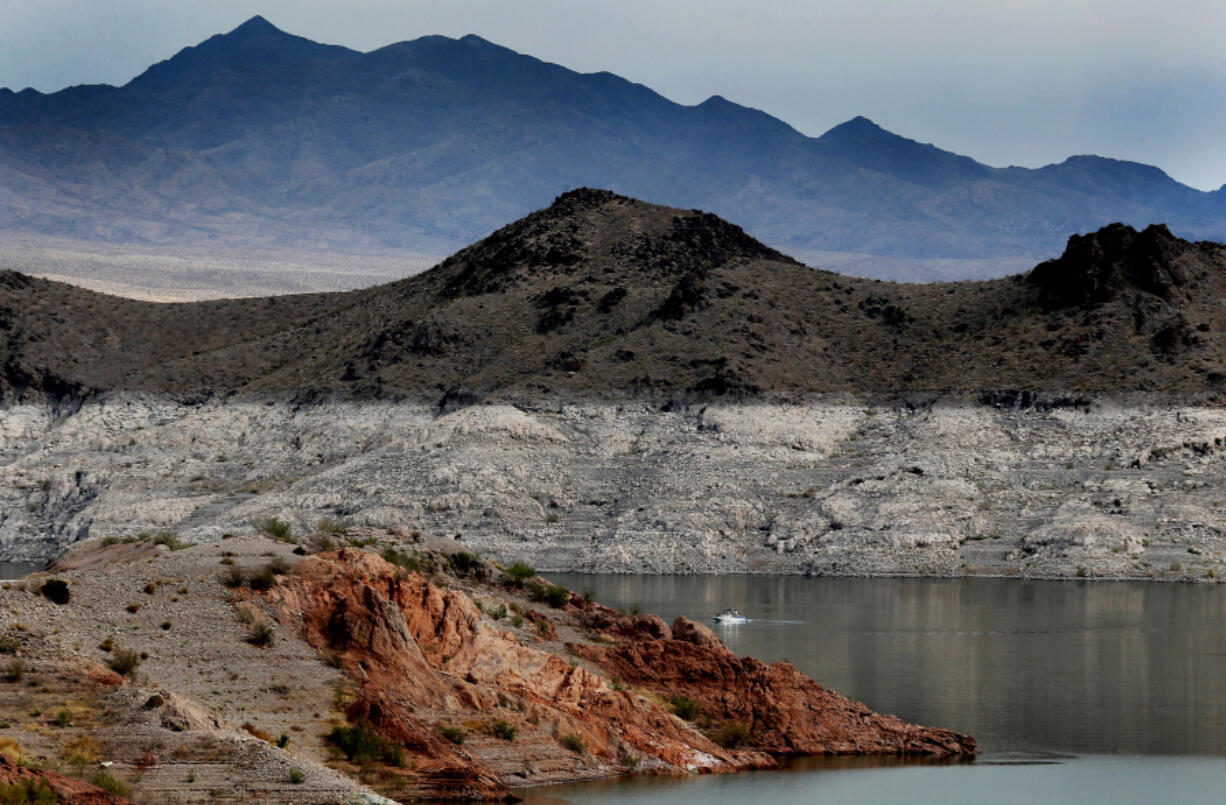 A boat navigates Lake Mead, where a white "bathtub ring" along the shore shows how far below capacity the nation's largest reservoir is on April 1, 2021. Water levels at Lake Mead hit their lowest point in history amid an ongoing megadrought, creating uncertainty about the water supply for millions in the Western U.S.