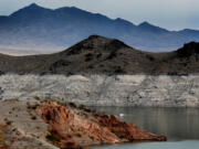 A boat navigates Lake Mead, where a white "bathtub ring" along the shore shows how far below capacity the nation's largest reservoir is on April 1, 2021. Water levels at Lake Mead hit their lowest point in history amid an ongoing megadrought, creating uncertainty about the water supply for millions in the Western U.S.