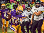 Columbia River's Kaden MacDonald (24) runs past Woodland? Tuker Ripp (66) during River's 16-7 over the Beavers on Friday, Sept.