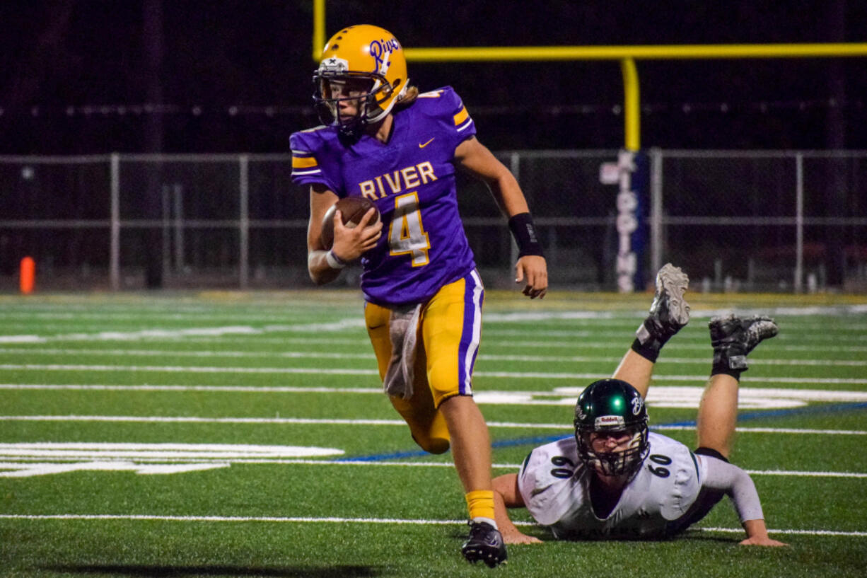 Columbia River quarterback Adam Watts (4) leaves Woodland's Malcolm Karchesky behind as Watts runs for a first down during River?s 16-7 win over Woodland on Friday, Sept.