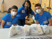 Huyen Truong and her two sons, working at an event this week between Ethnic Support Council and Youth and Family Link.