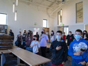 Seventh-grade students pause for the Pledge of Allegiance as they have their homeroom in the library, which is still being unpacked, at the new La Center Middle School. It's the first new school building in the district since the early 1990s.