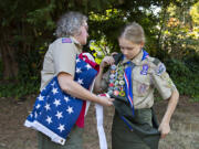 Helene Abbott, left, helps her daughter, Josephine Abbott, 14, as she prepares for a portrait at her home. Josephine has become the first female Eagle Scout in Southwest Washington.